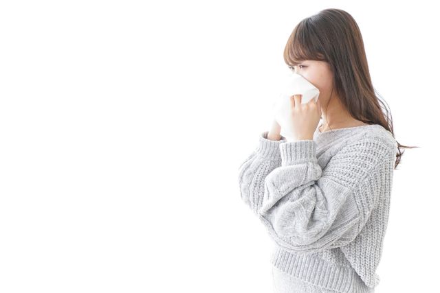 鼻炎で鼻をかむ女性